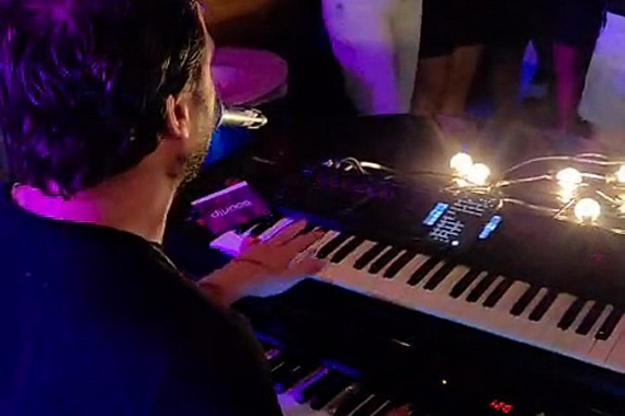 Karaoke pianist achter de piano tijdens een optreden
