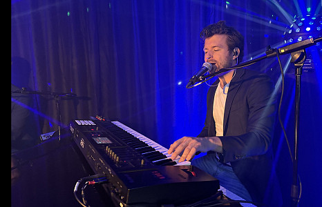 Karaoke pianist achter de piano tijdens een optreden